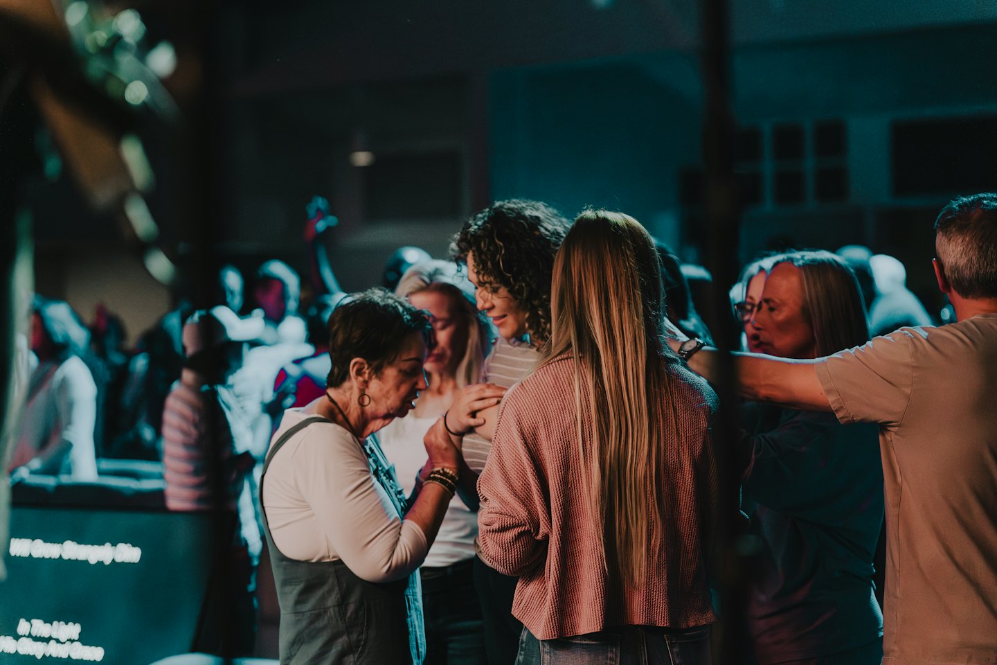 Two women holding hands during a community gathering.